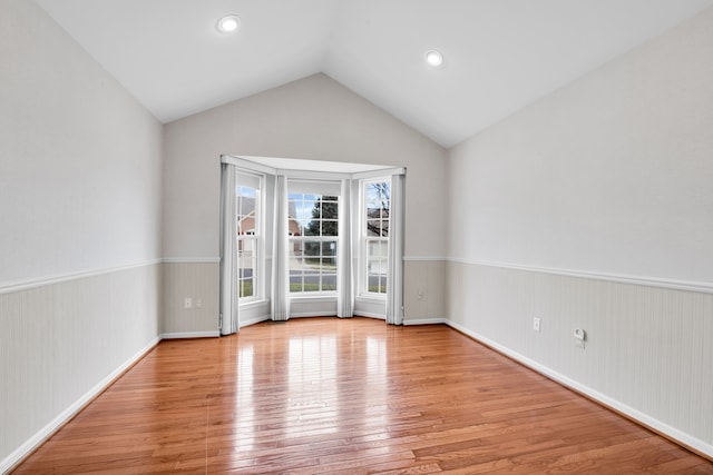 empty room with lofted ceiling and light hardwood / wood-style flooring