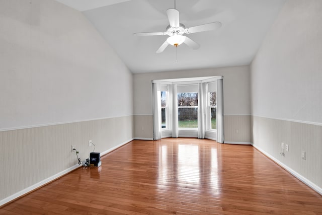 spare room featuring lofted ceiling, light hardwood / wood-style flooring, and ceiling fan