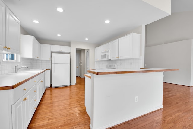 kitchen featuring sink, white cabinets, white appliances, and kitchen peninsula