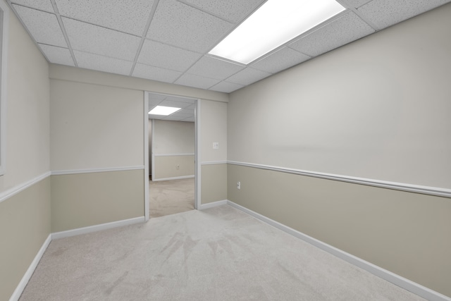 carpeted spare room featuring a paneled ceiling