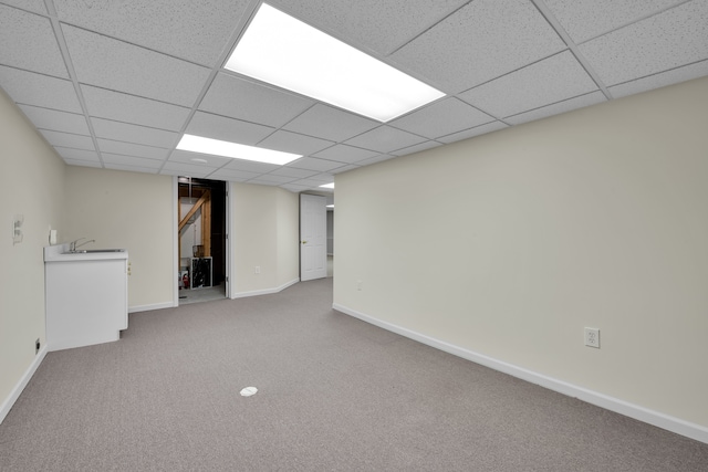 basement featuring sink, carpet, and a drop ceiling