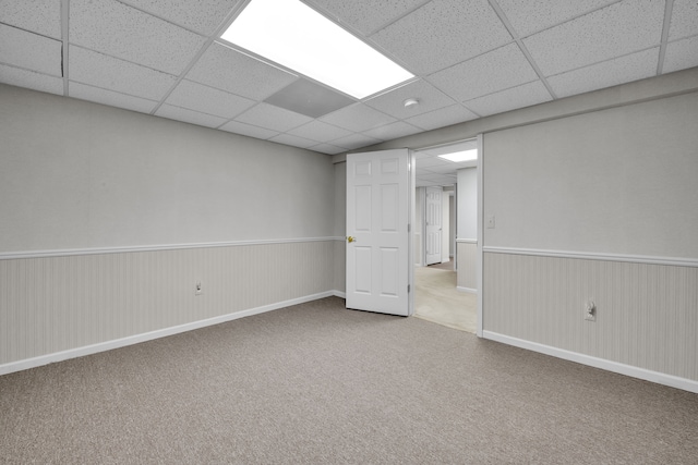 unfurnished room with a paneled ceiling and carpet