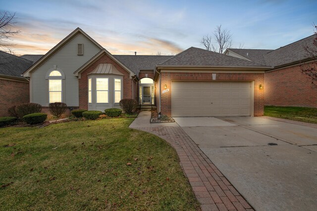 ranch-style house featuring a lawn and a garage