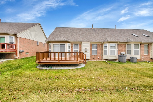 back of property with a deck and a lawn