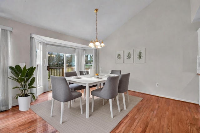 dining area featuring high vaulted ceiling, light hardwood / wood-style flooring, and a notable chandelier