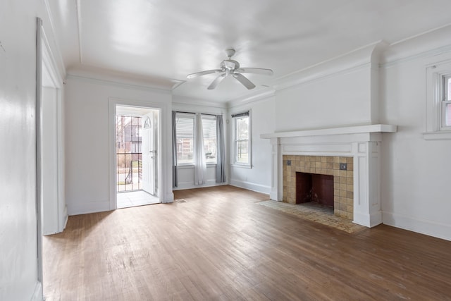 unfurnished living room with a tiled fireplace, ceiling fan, hardwood / wood-style floors, and ornamental molding