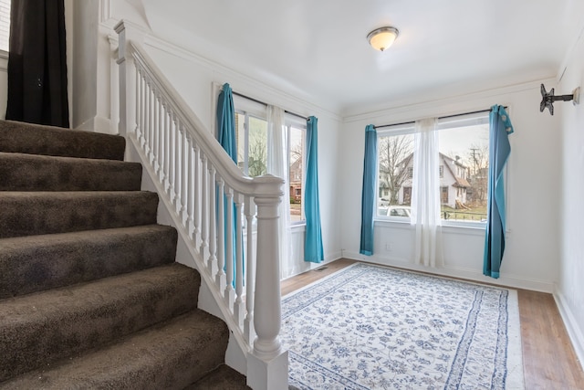 foyer entrance with hardwood / wood-style floors, a healthy amount of sunlight, and ornamental molding