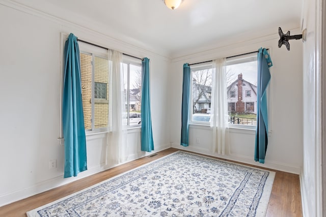 doorway to outside with wood-type flooring and ornamental molding