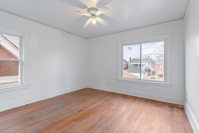 empty room featuring ceiling fan, crown molding, and hardwood / wood-style flooring