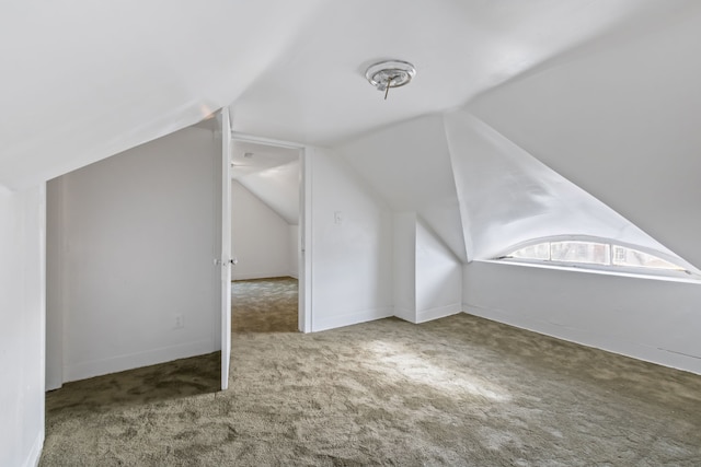 bonus room with carpet flooring and vaulted ceiling