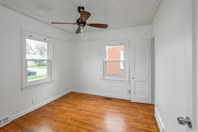 empty room featuring ceiling fan, a textured ceiling, and light wood-type flooring