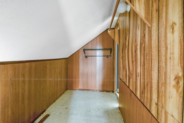 bonus room featuring wood walls and vaulted ceiling