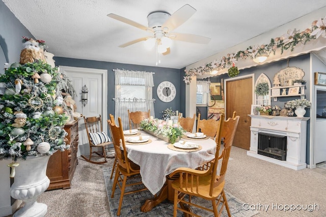 dining space with carpet, ceiling fan, and a textured ceiling