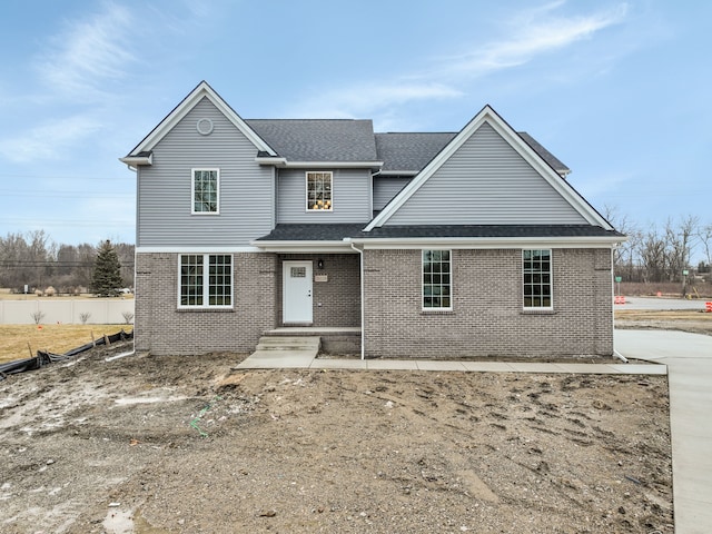 traditional home with brick siding and roof with shingles