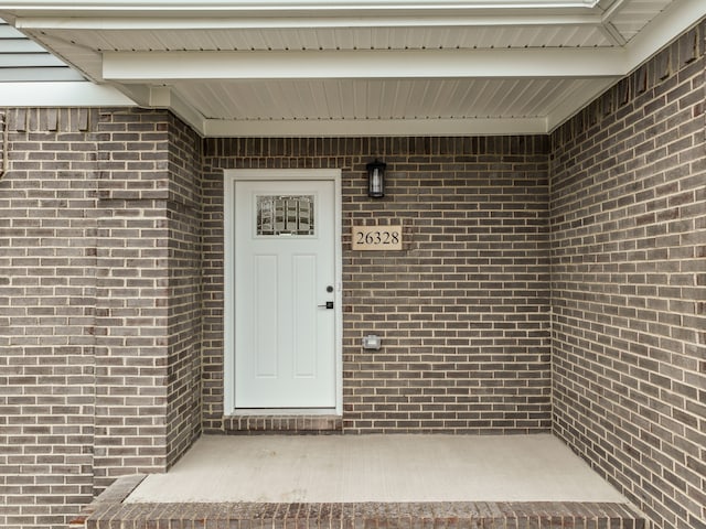 doorway to property with brick siding