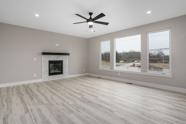 unfurnished living room featuring a fireplace, recessed lighting, visible vents, wood finished floors, and baseboards