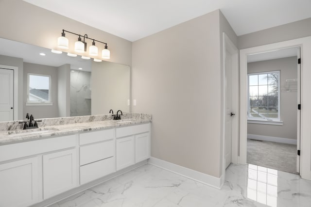 bathroom featuring marble finish floor, double vanity, a sink, and baseboards