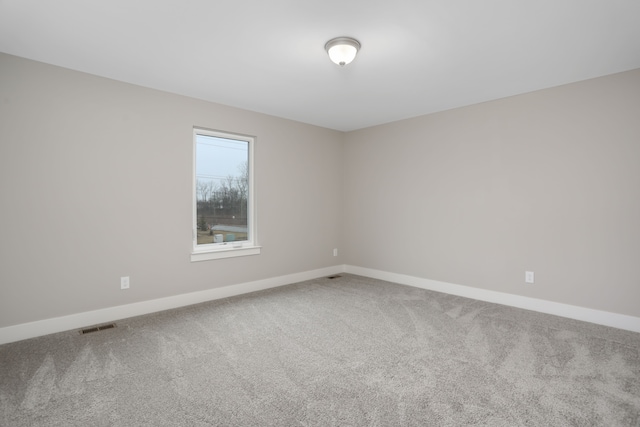 carpeted empty room with visible vents and baseboards