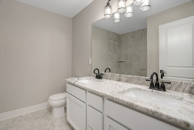 bathroom with marble finish floor, a sink, toilet, and baseboards