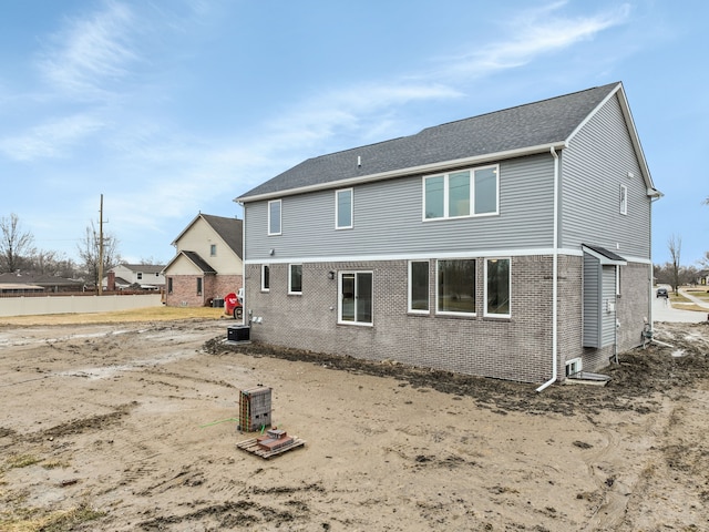 rear view of house featuring central AC and brick siding