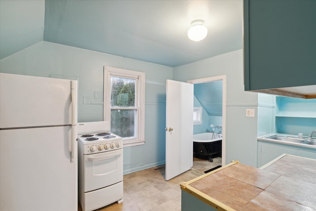 kitchen featuring tile counters, white appliances, sink, and vaulted ceiling