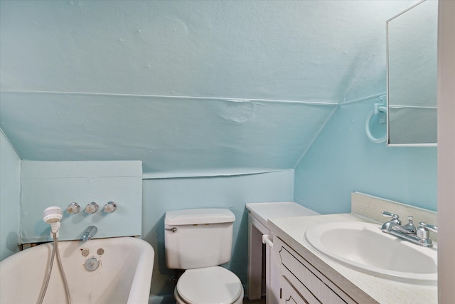 bathroom featuring a bathtub, vanity, vaulted ceiling, and toilet