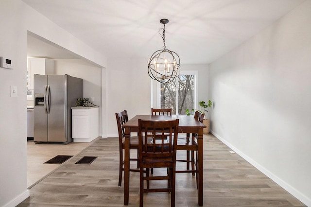 dining room featuring a notable chandelier and light hardwood / wood-style flooring