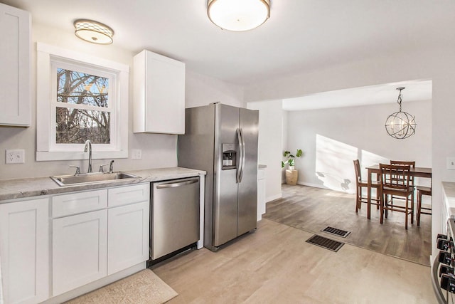 kitchen with light hardwood / wood-style flooring, stainless steel appliances, white cabinets, and sink