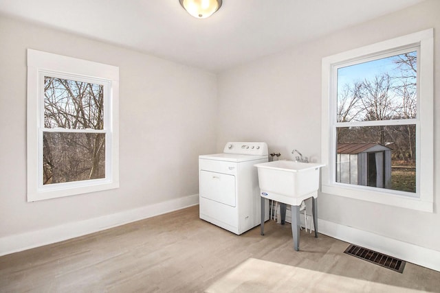 laundry area featuring washer / dryer and light wood-type flooring