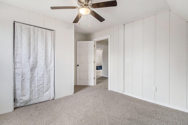 unfurnished bedroom featuring ceiling fan, vaulted ceiling, and carpet floors