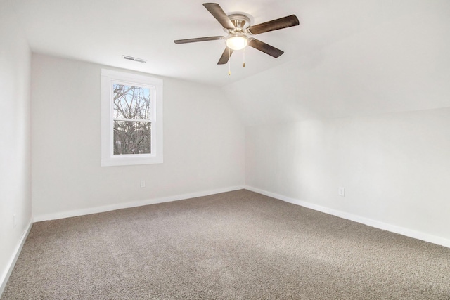 carpeted spare room featuring ceiling fan and vaulted ceiling