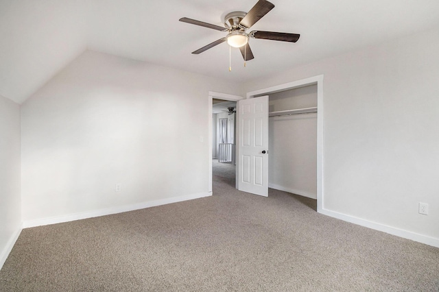 unfurnished bedroom with ceiling fan, vaulted ceiling, a closet, and carpet flooring