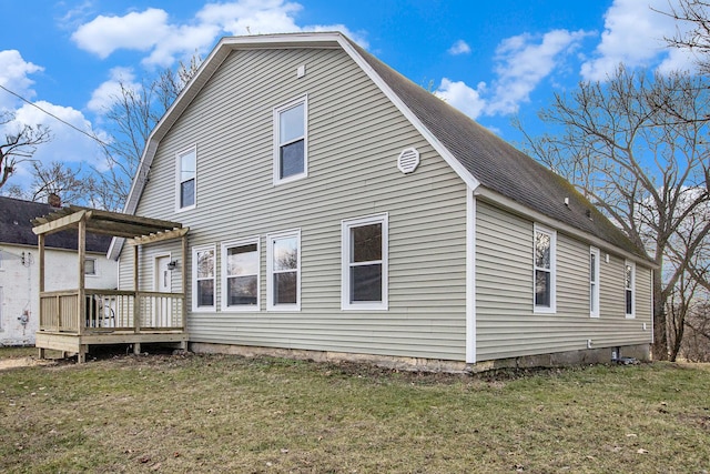 back of house featuring a wooden deck, a lawn, and a pergola