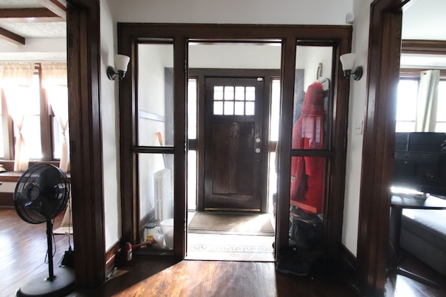 foyer entrance featuring beam ceiling and dark wood-type flooring