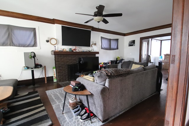 living room featuring crown molding, a fireplace, ceiling fan, and dark hardwood / wood-style floors