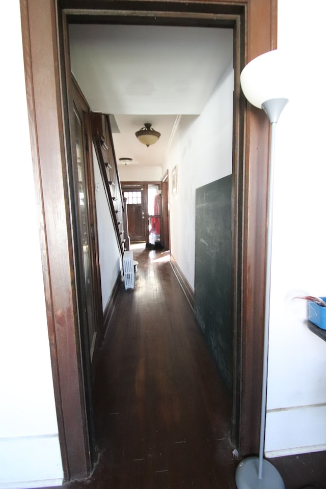 hall with dark hardwood / wood-style flooring and crown molding