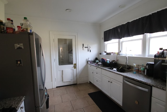 kitchen featuring white cabinetry, sink, crown molding, light tile patterned floors, and appliances with stainless steel finishes