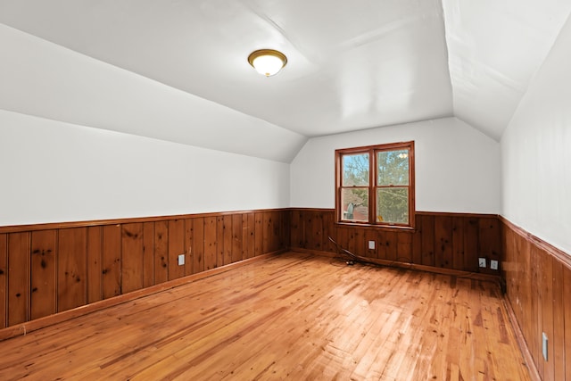 additional living space featuring light hardwood / wood-style flooring and vaulted ceiling