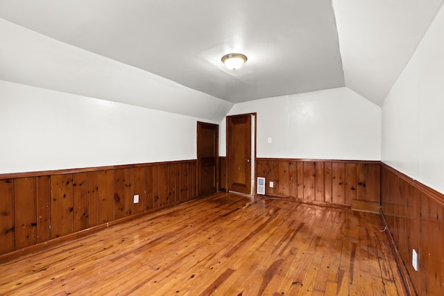 additional living space featuring lofted ceiling and hardwood / wood-style flooring