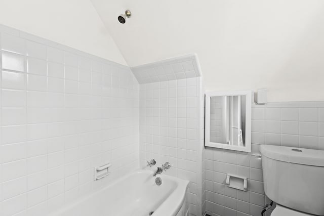 bathroom with tiled shower / bath, toilet, tile walls, and lofted ceiling