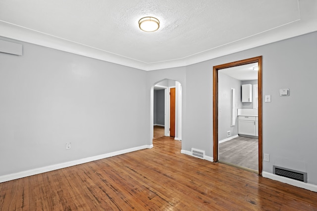 spare room with hardwood / wood-style flooring and a textured ceiling