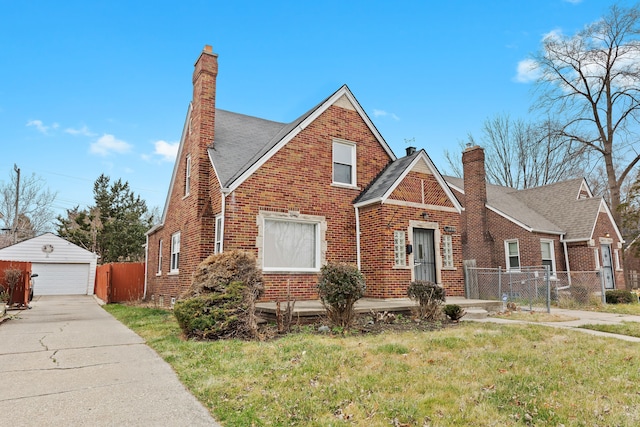 view of front of home with a garage, an outdoor structure, and a front yard