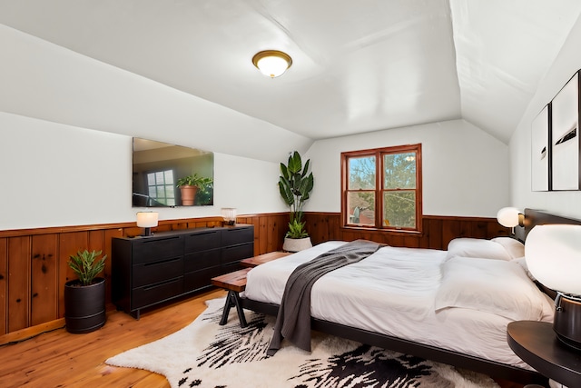 bedroom featuring light hardwood / wood-style floors and vaulted ceiling