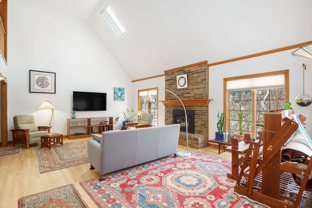 living room featuring hardwood / wood-style floors, a wood stove, high vaulted ceiling, and a skylight