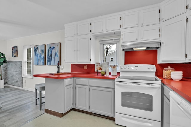 kitchen with white cabinetry, light hardwood / wood-style flooring, white appliances, and ornamental molding