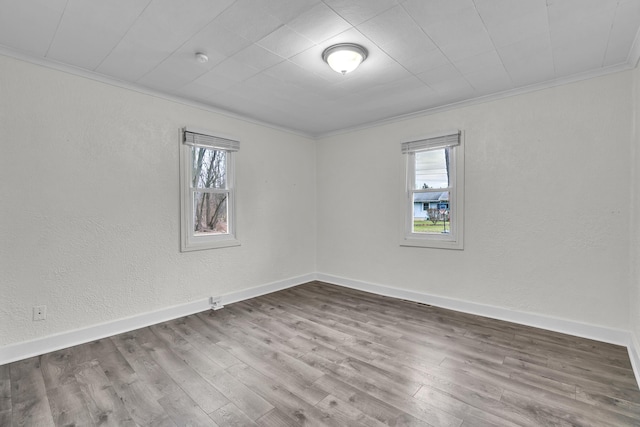 empty room featuring ornamental molding and hardwood / wood-style flooring