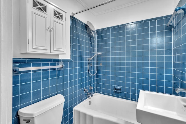 full bathroom featuring tiled shower / bath combo, crown molding, sink, tile walls, and toilet