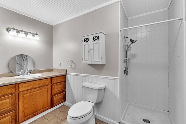 bathroom with tile patterned floors, a tile shower, vanity, crown molding, and toilet