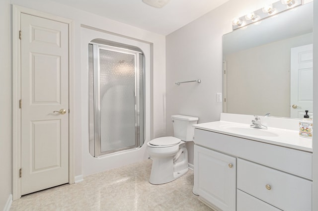 bathroom featuring vanity, toilet, and an enclosed shower