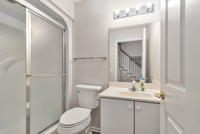 bathroom with vanity, toilet, and a shower with door